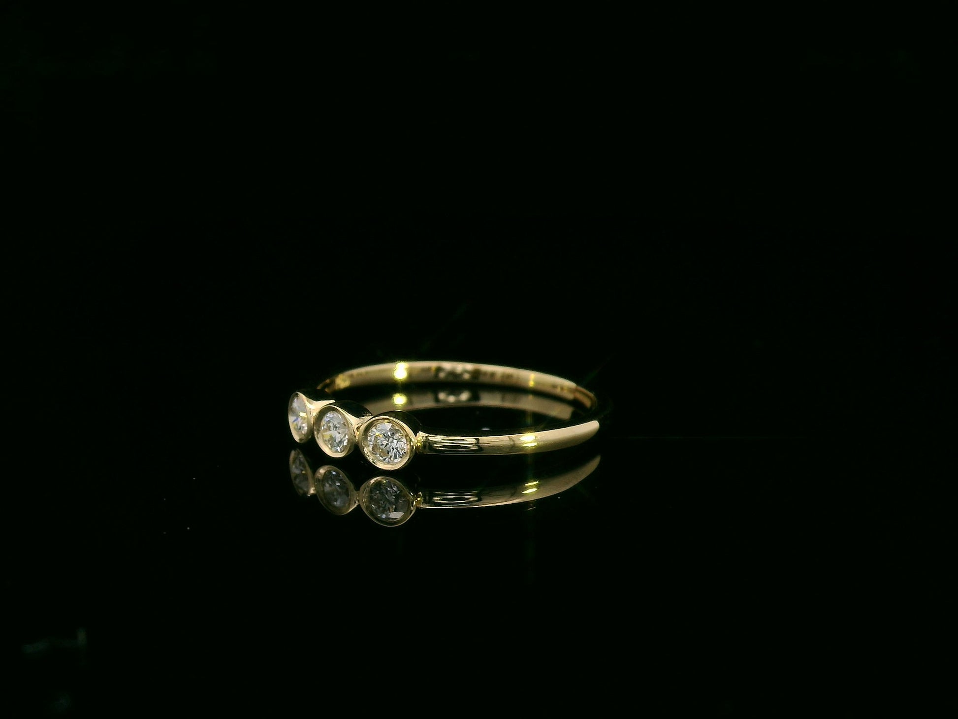 18K yellow gold three-stone natural diamond ring with minimalist bezel setting by Emirates Diamonds