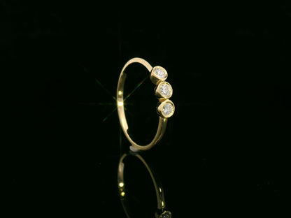 18K yellow gold three-stone natural diamond ring with minimalist bezel setting by Emirates Diamonds