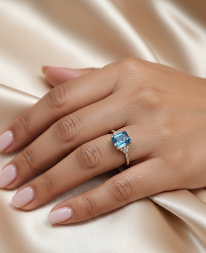 Emerald-cut blue topaz and diamond ring in 18K yellow gold by Emirates Diamonds.