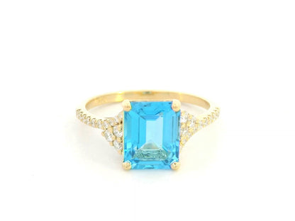 Emerald-cut blue topaz and diamond ring in 18K yellow gold by Emirates Diamonds.