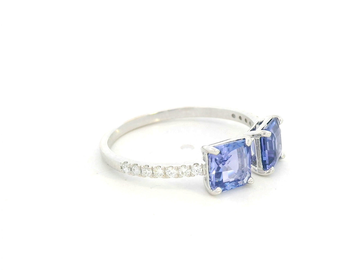 18K white gold open ring featuring two square emerald-cut tanzanites totaling 1.72 carats with 0.13 carat diamond accents by Emirates Diamonds.