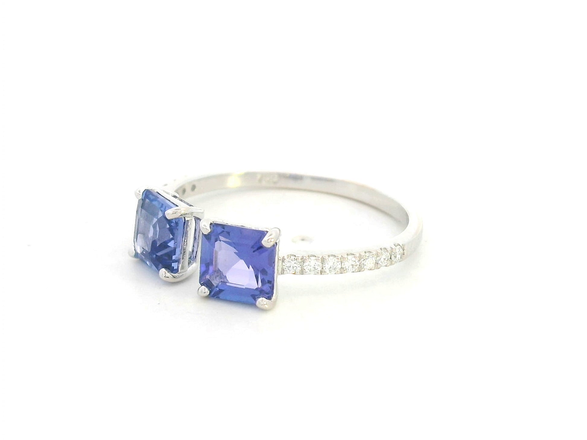 18K white gold open ring featuring two square emerald-cut tanzanites totaling 1.72 carats with 0.13 carat diamond accents by Emirates Diamonds.