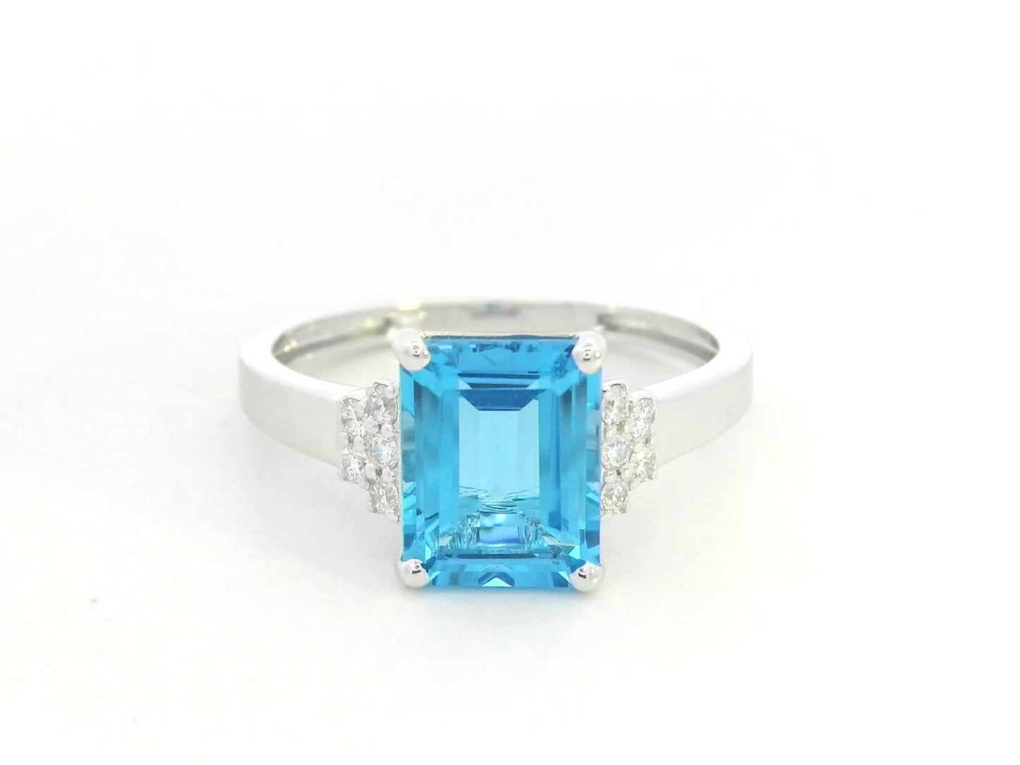 18K white gold emerald-cut Swiss blue topaz ring with diamond side accents by Emirates Diamonds