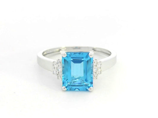 18K white gold emerald-cut Swiss blue topaz ring with diamond side accents by Emirates Diamonds