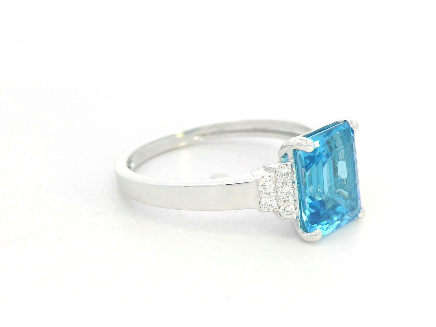18K white gold emerald-cut Swiss blue topaz ring with diamond side accents by Emirates Diamonds