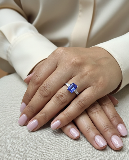 Emerald cut tanzanite and diamond ring in 18K white gold with tapered diamond side stones by Emirates Diamonds