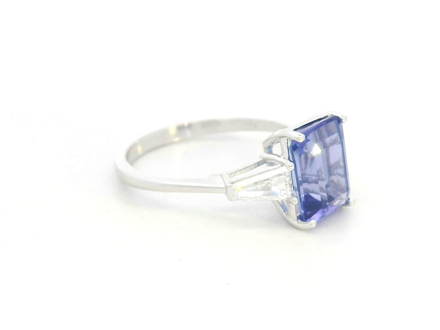 Emerald cut tanzanite and diamond ring in 18K white gold with tapered diamond side stones by Emirates Diamonds