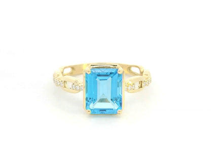 Emerald-cut Swiss blue topaz and diamond ring in 18K yellow gold by Emirates Diamonds.