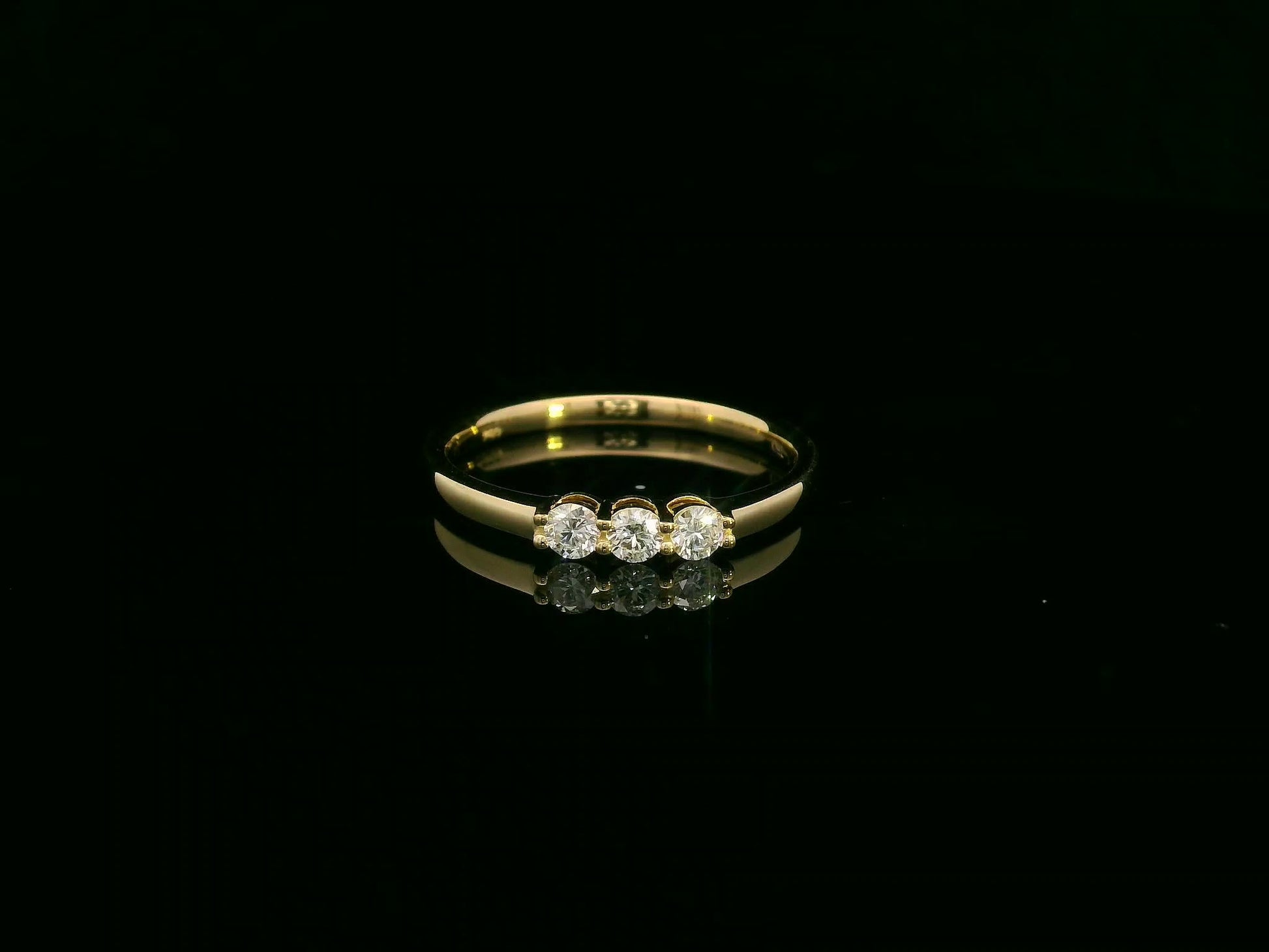 18K yellow gold diamond three-stone ring with round brilliant diamonds, classic trilogy ring design by Emirates Diamonds