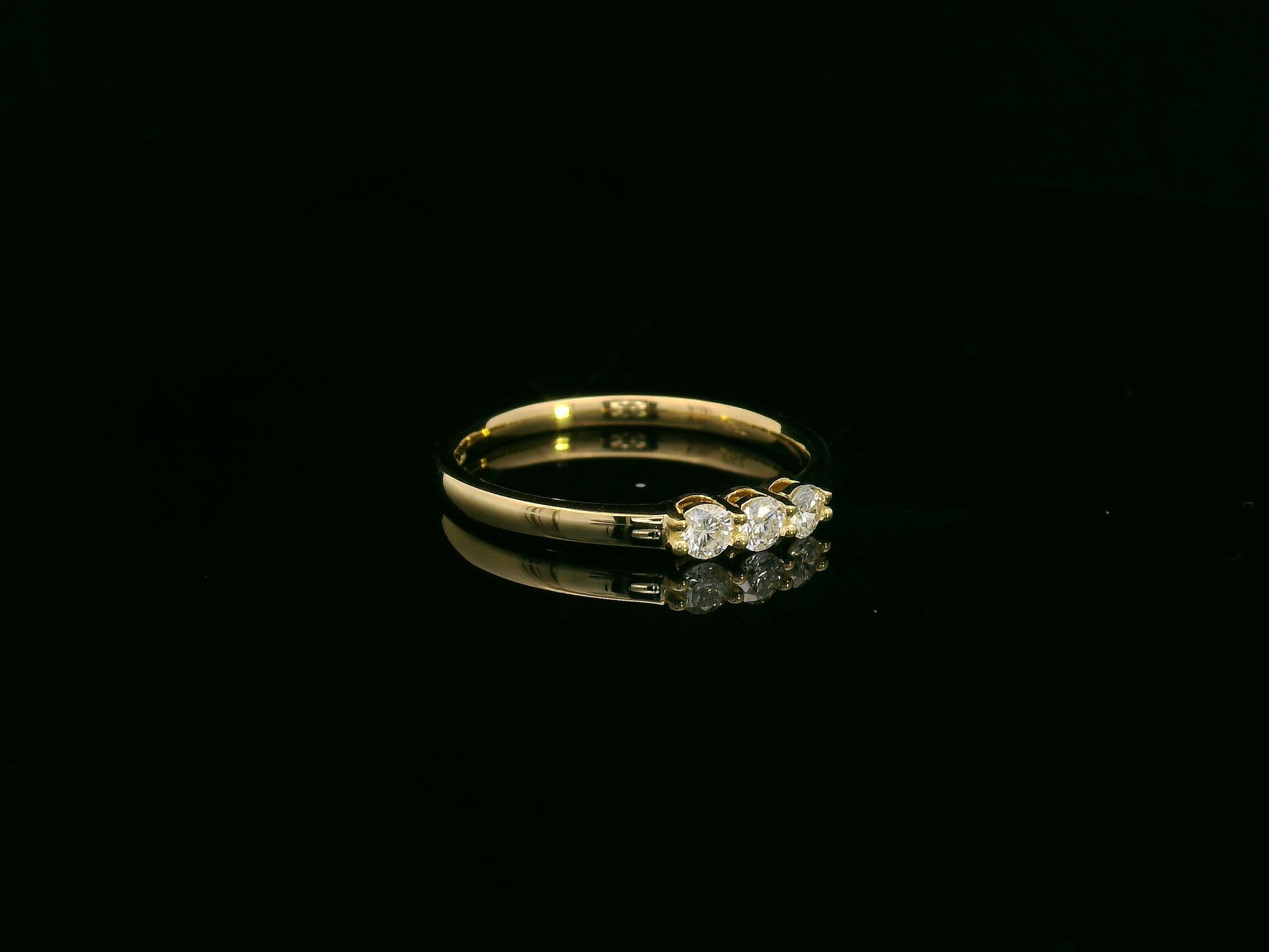18K yellow gold diamond three-stone ring with round brilliant diamonds, classic trilogy ring design by Emirates Diamonds
