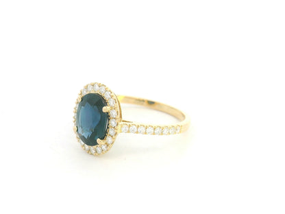 18K yellow gold blue sapphire and diamond halo ring with oval sapphire centerpiece by Emirates Diamonds
