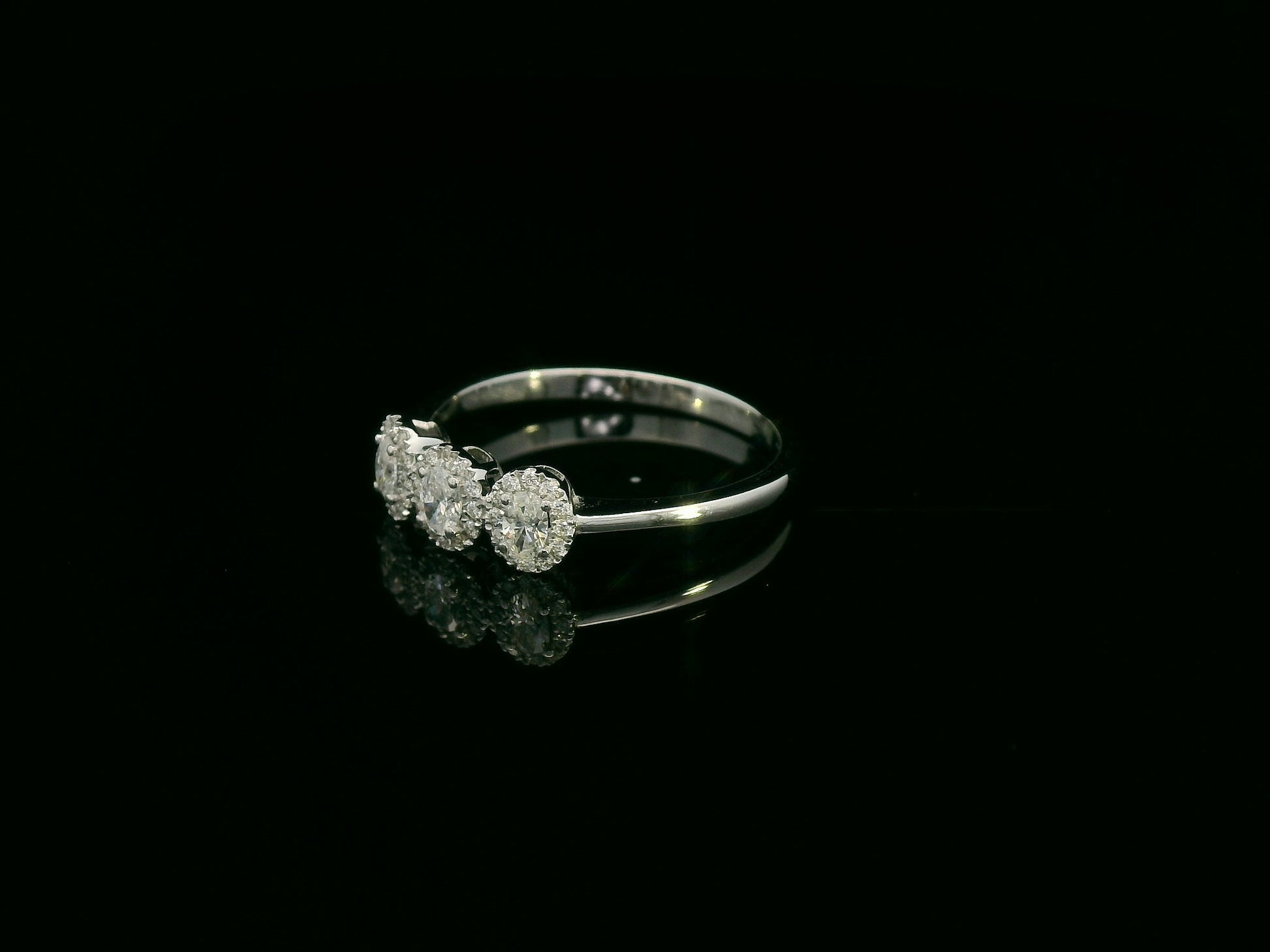 Diamond trilogy halo ring in 18K white gold with three round diamond clusters