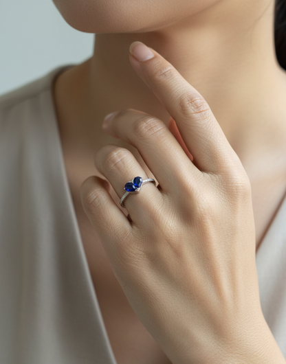 18K white gold  heart ring featuring two blue sapphires totaling 1.08 carat with 0.10 carat diamond accents by Emirates Diamonds.