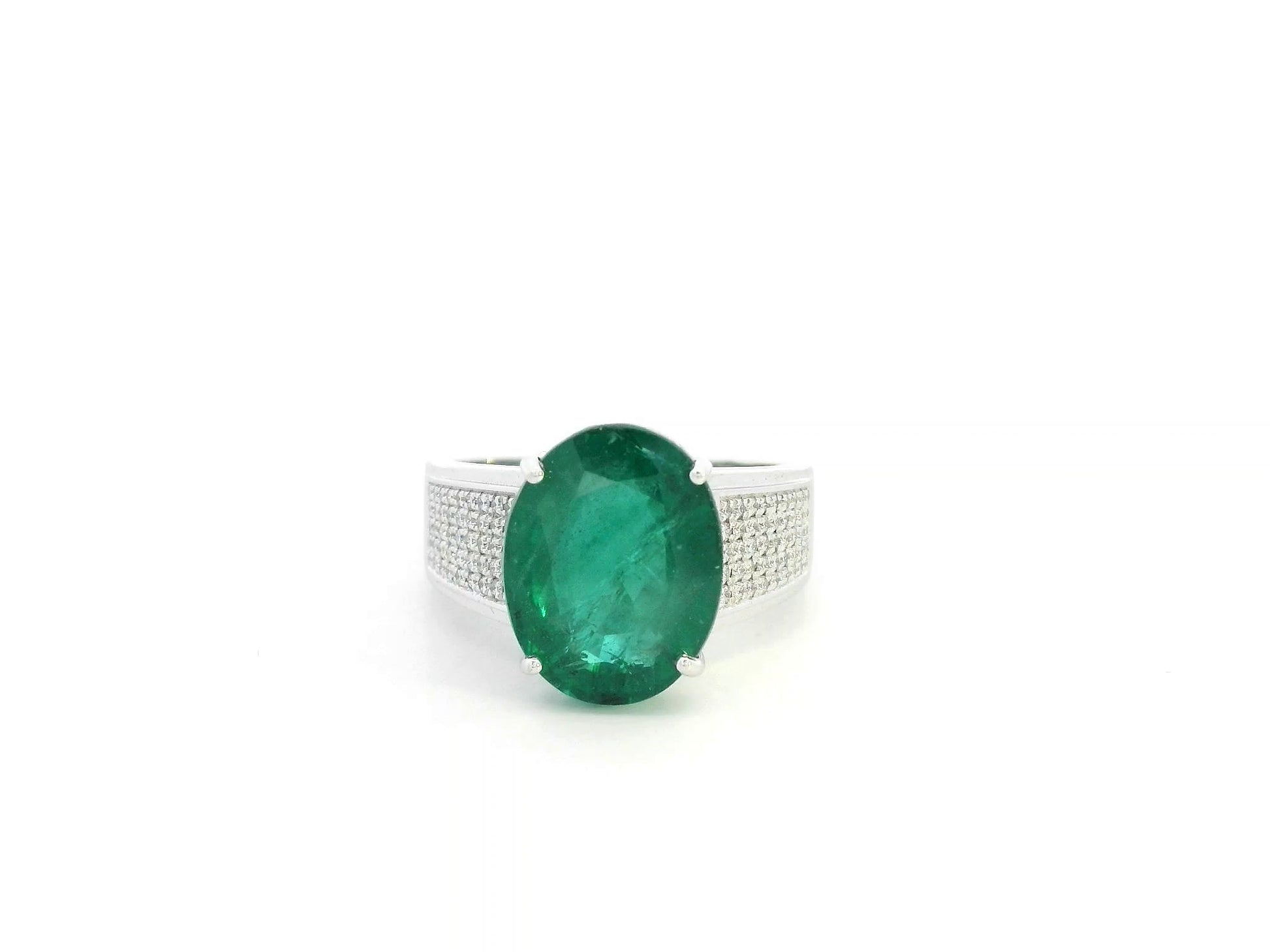 Oval emerald statement ring in 18K white gold with diamond-set shoulders by Emirates Diamonds.