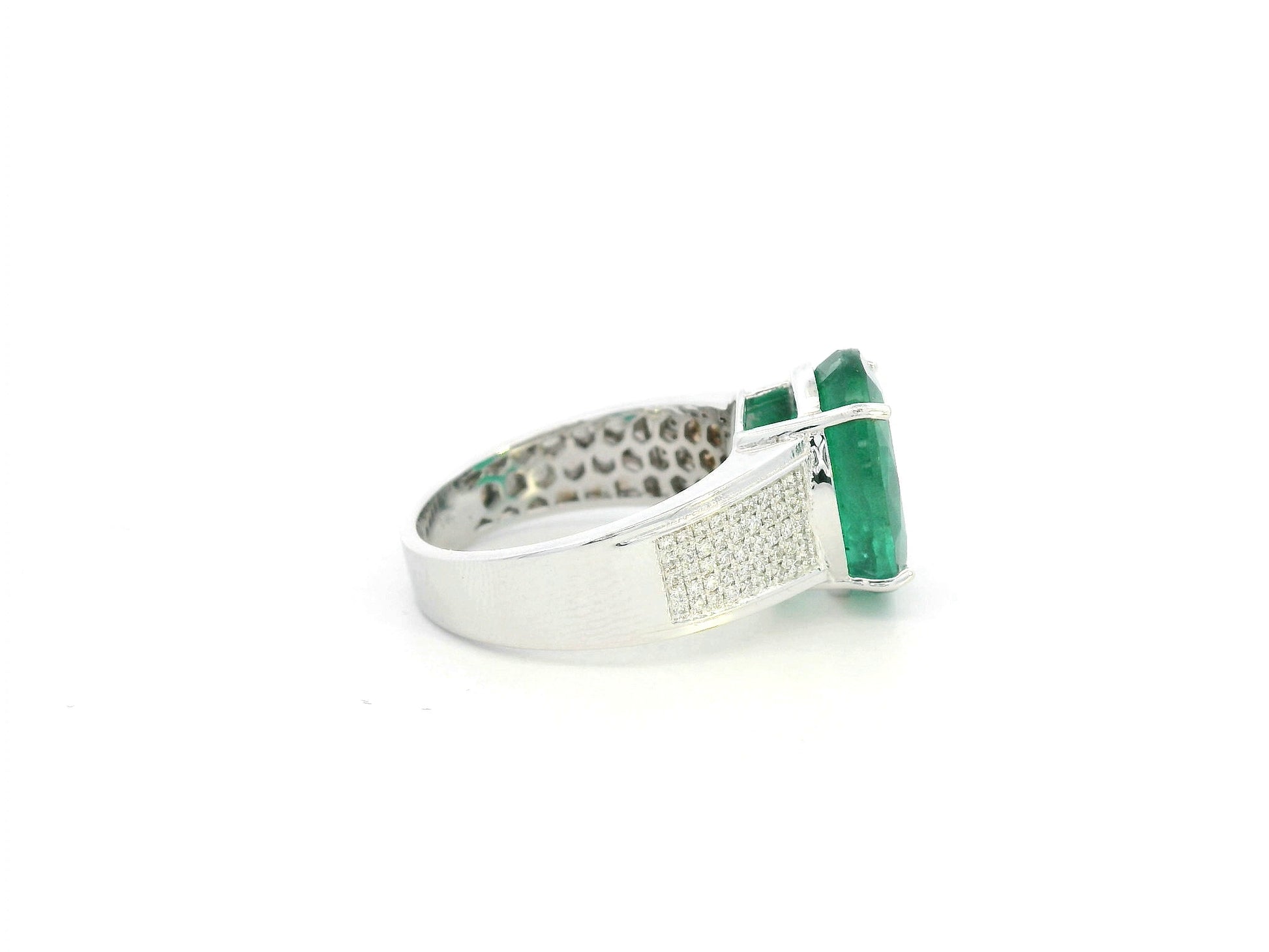 Oval emerald statement ring in 18K white gold with diamond-set shoulders by Emirates Diamonds.