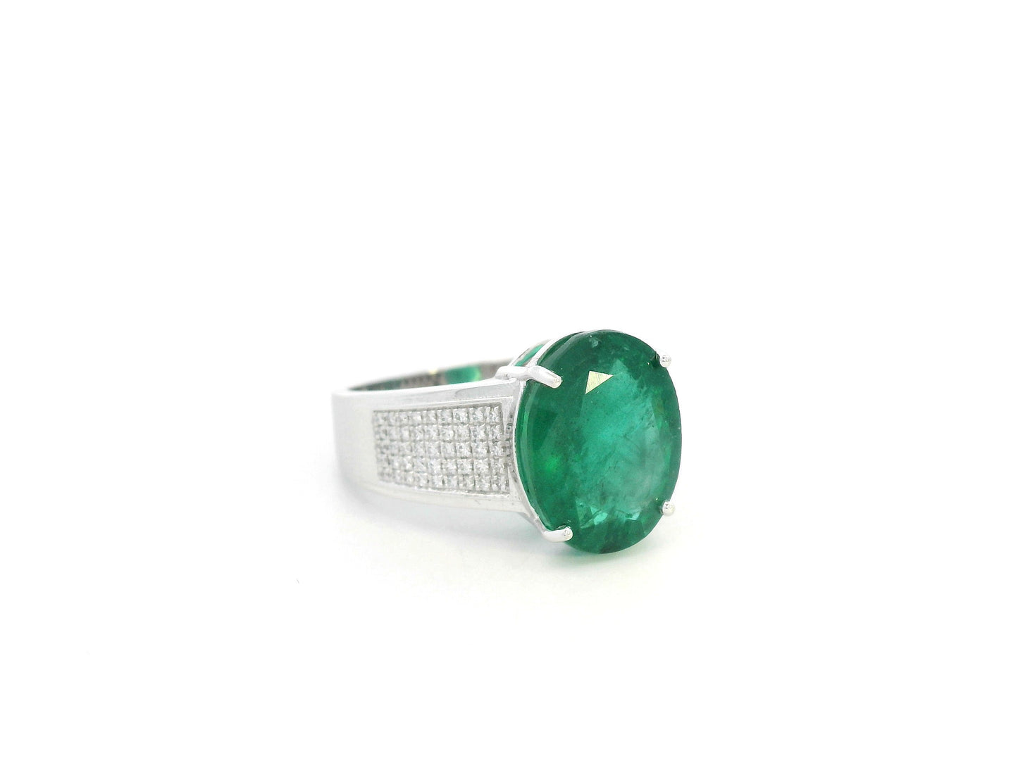 Oval emerald statement ring in 18K white gold with diamond-set shoulders by Emirates Diamonds.
