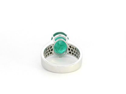 Oval emerald statement ring in 18K white gold with diamond-set shoulders by Emirates Diamonds.