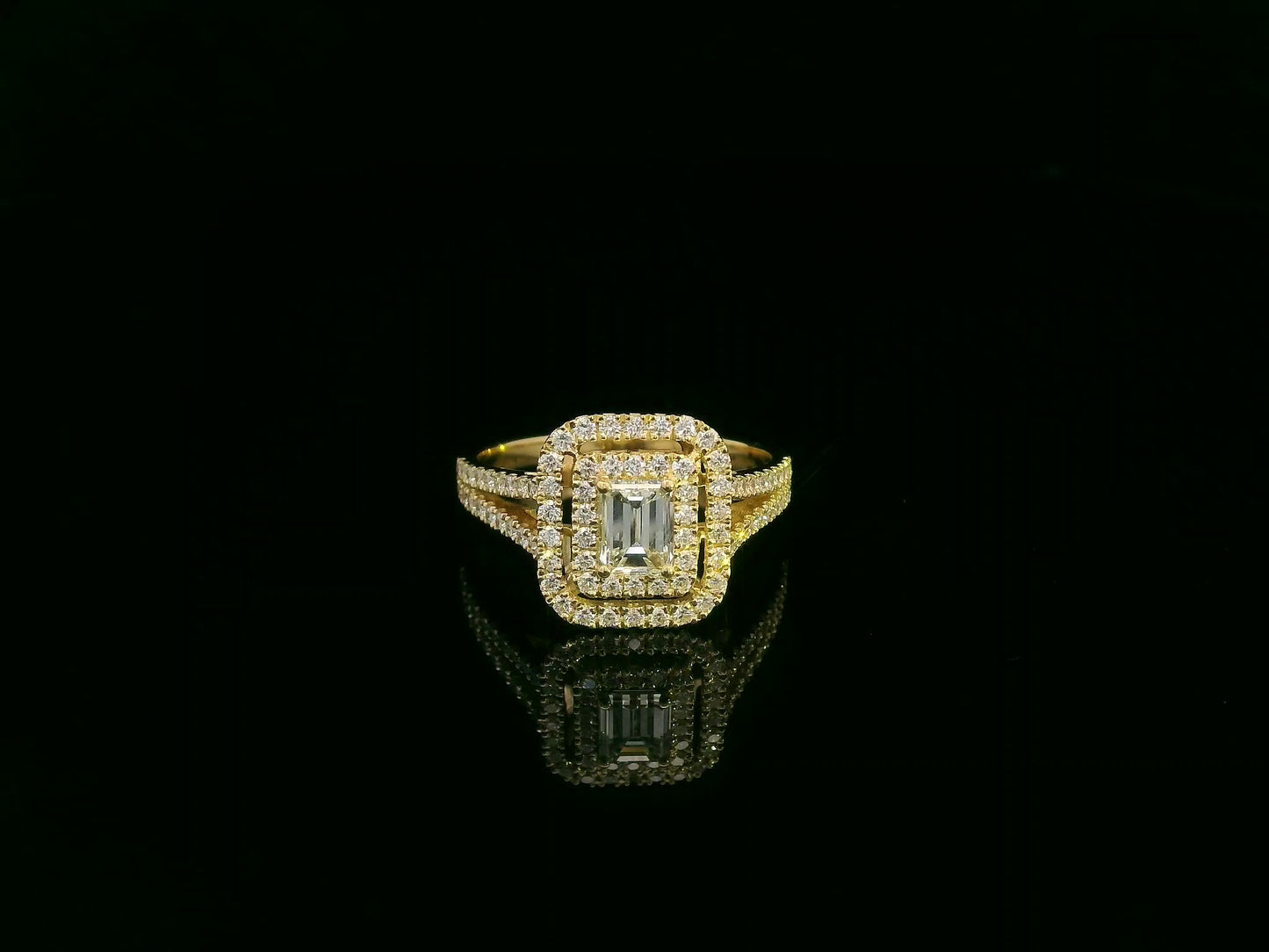 0.58 carat IGI certified emerald cut diamond halo ring in 18K yellow gold with 0.56 carat pavé diamonds by Emirates Diamonds.