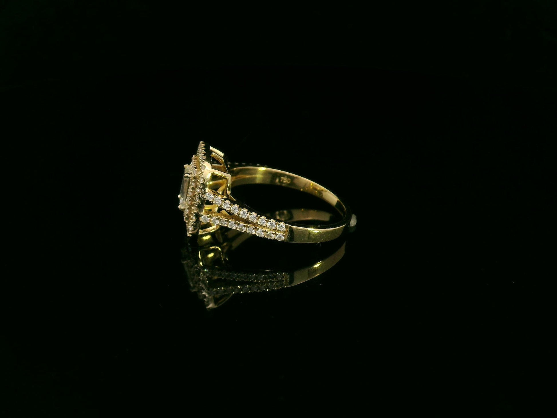 0.58 carat IGI certified emerald cut diamond halo ring in 18K yellow gold with 0.56 carat pavé diamonds by Emirates Diamonds.