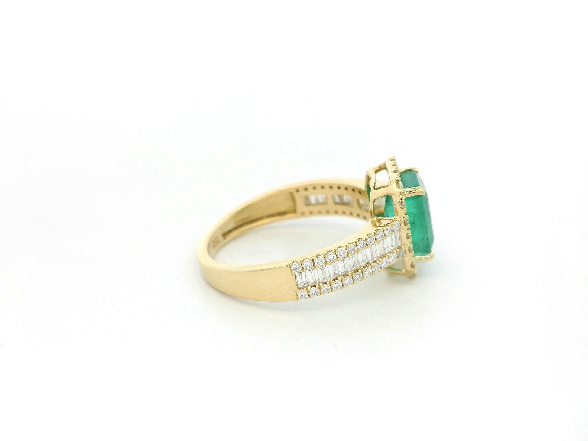 18K yellow gold emerald and diamond halo ring with baguette diamond accents by Emirates Diamonds.