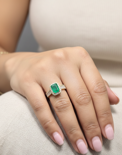 18K yellow gold emerald and diamond halo ring with baguette diamond accents by Emirates Diamonds.