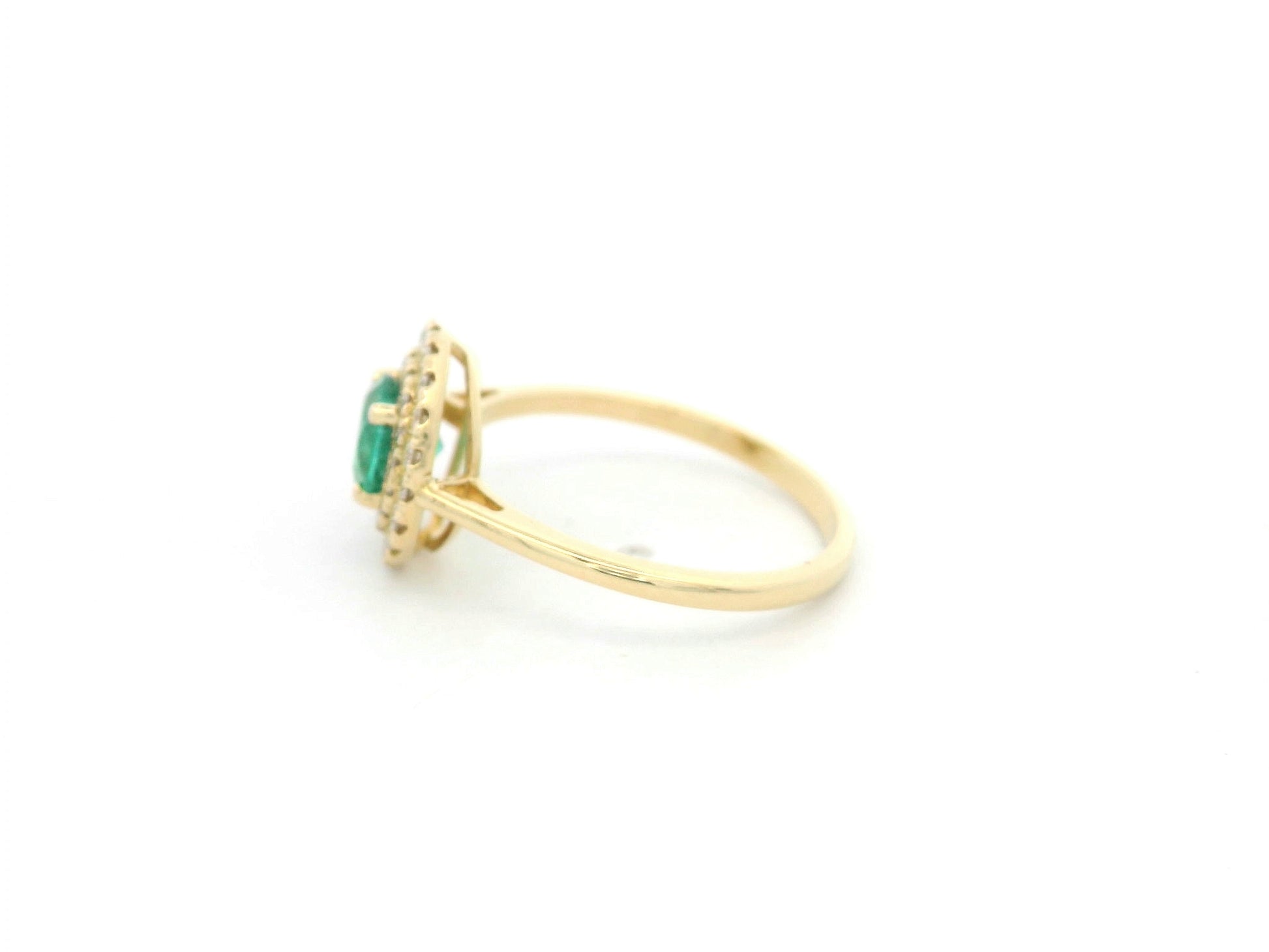 18K yellow gold emerald and diamond halo ring with round emerald center, luxury fine jewelry by Emirates Diamonds.
