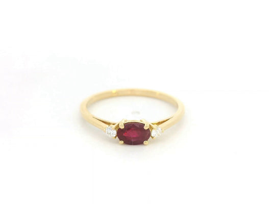 18K yellow gold ruby and diamond solitaire ring featuring an oval ruby with delicate diamond accents by Emirates Diamonds.