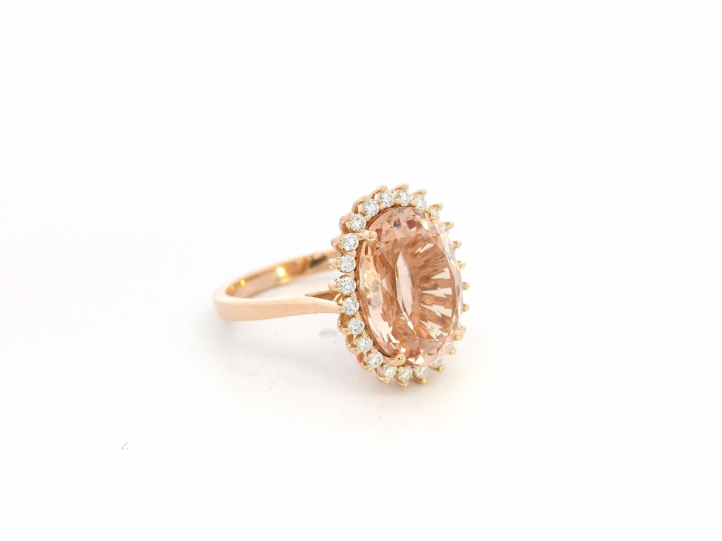18K rose gold morganite and diamond halo ring featuring an oval morganite and sparkling diamond accents by Emirates Diamonds.