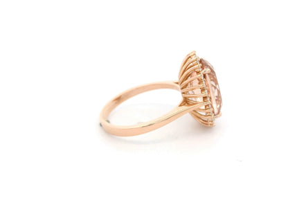 18K rose gold morganite and diamond halo ring featuring an oval morganite and sparkling diamond accents by Emirates Diamonds.