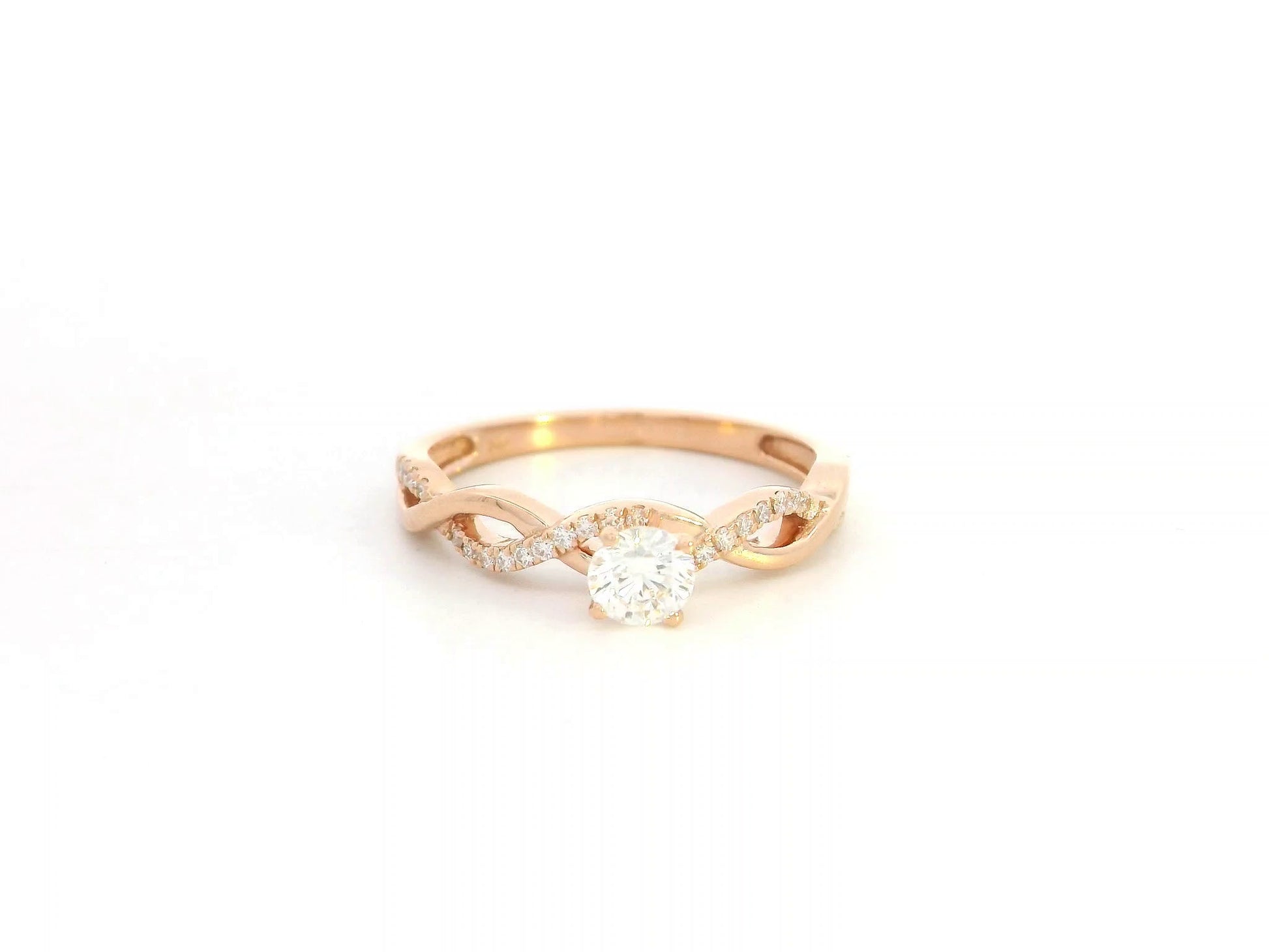 0.32 carat diamond solitaire twist engagement ring in 18K rose gold with pavé band by Emirates Diamonds