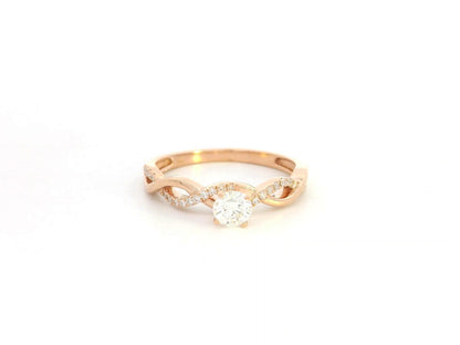 0.32 carat diamond solitaire twist engagement ring in 18K rose gold with pavé band by Emirates Diamonds
