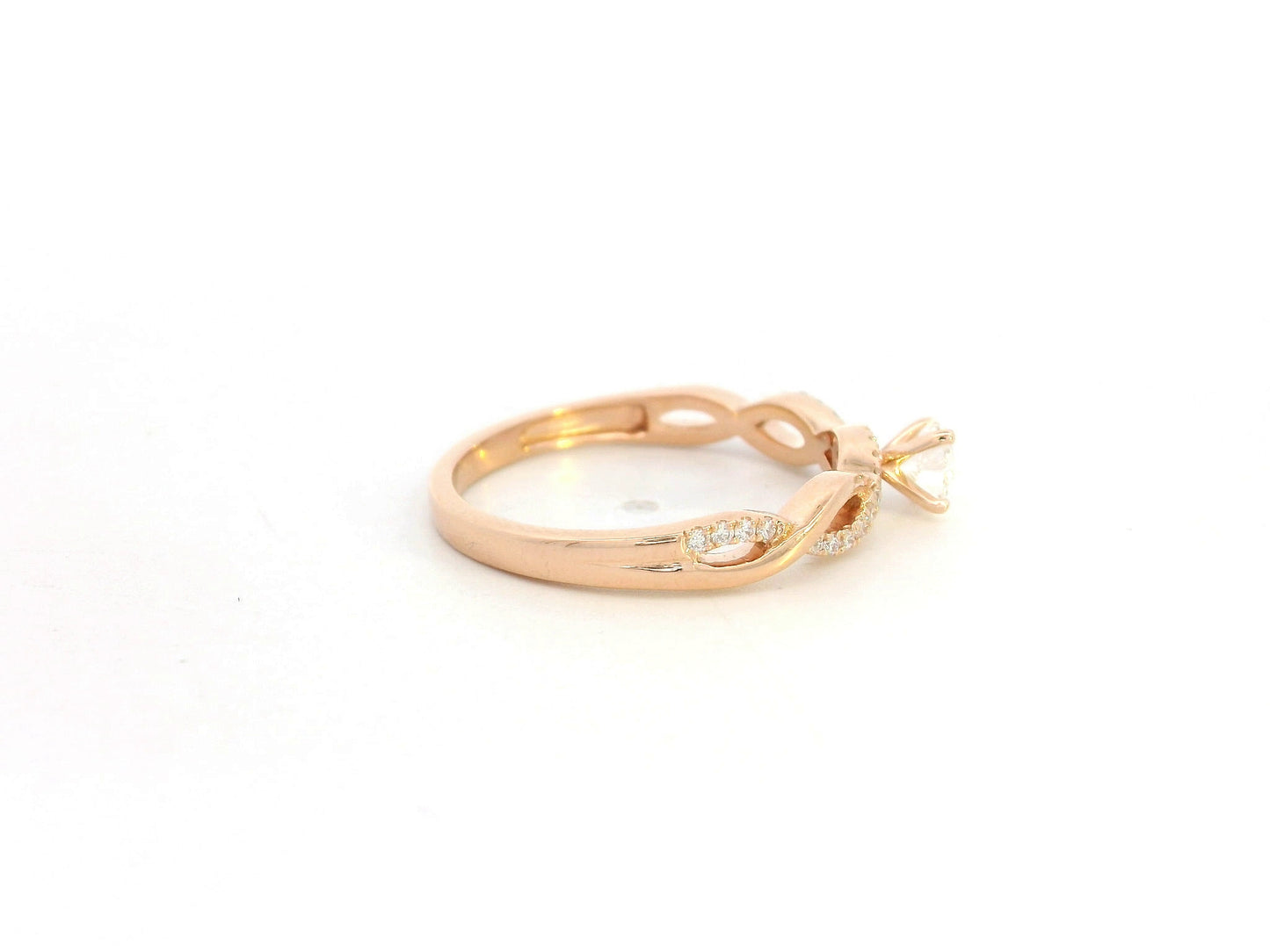0.32 carat diamond solitaire twist engagement ring in 18K rose gold with pavé band by Emirates Diamonds