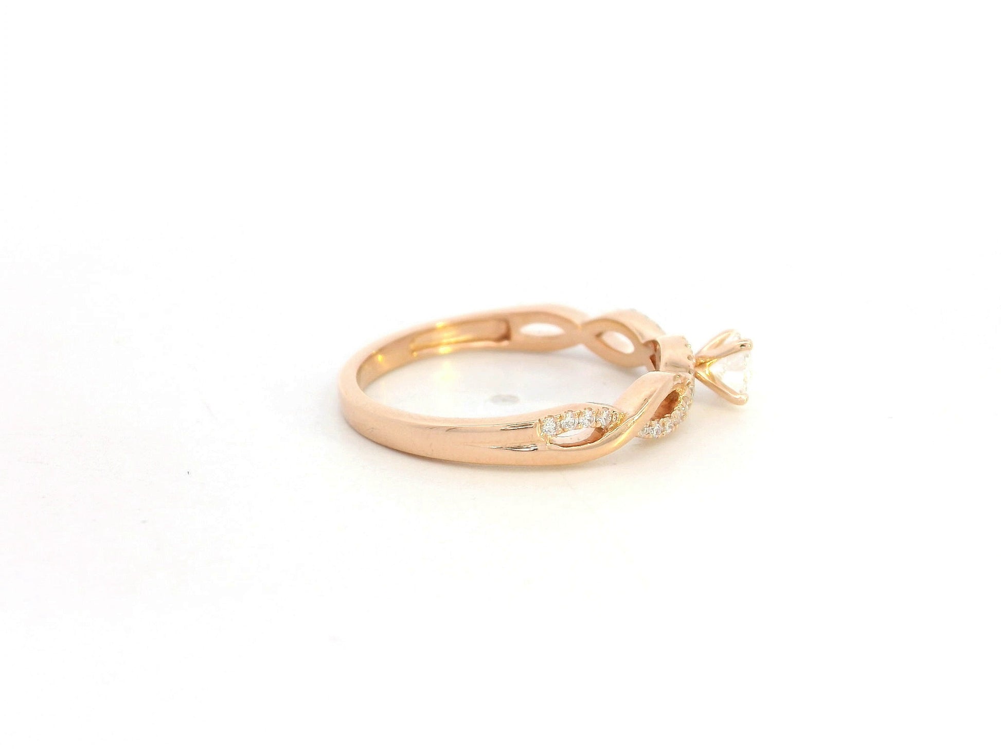 0.32 carat diamond solitaire twist engagement ring in 18K rose gold with pavé band by Emirates Diamonds