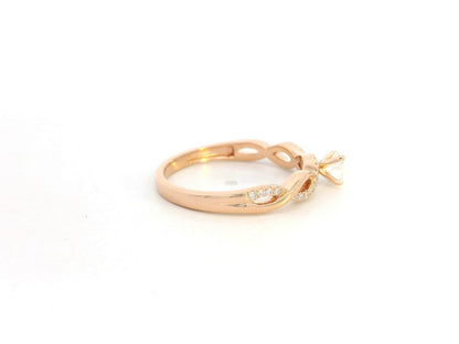 0.32 carat diamond solitaire twist engagement ring in 18K rose gold with pavé band by Emirates Diamonds