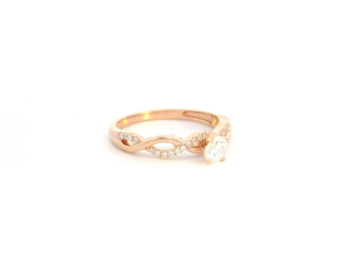 0.32 carat diamond solitaire twist engagement ring in 18K rose gold with pavé band by Emirates Diamonds