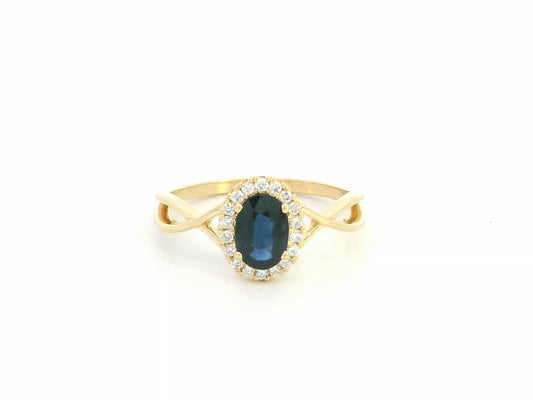 Oval blue sapphire diamond halo ring in 18K yellow gold with crossover band by Emirates Diamonds