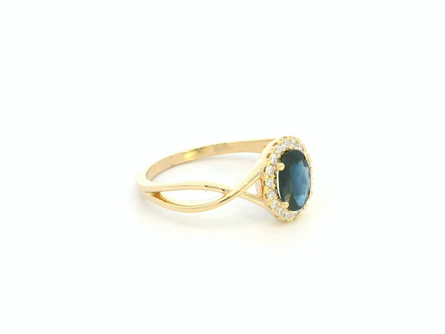 Oval blue sapphire diamond halo ring in 18K yellow gold with crossover band by Emirates Diamonds