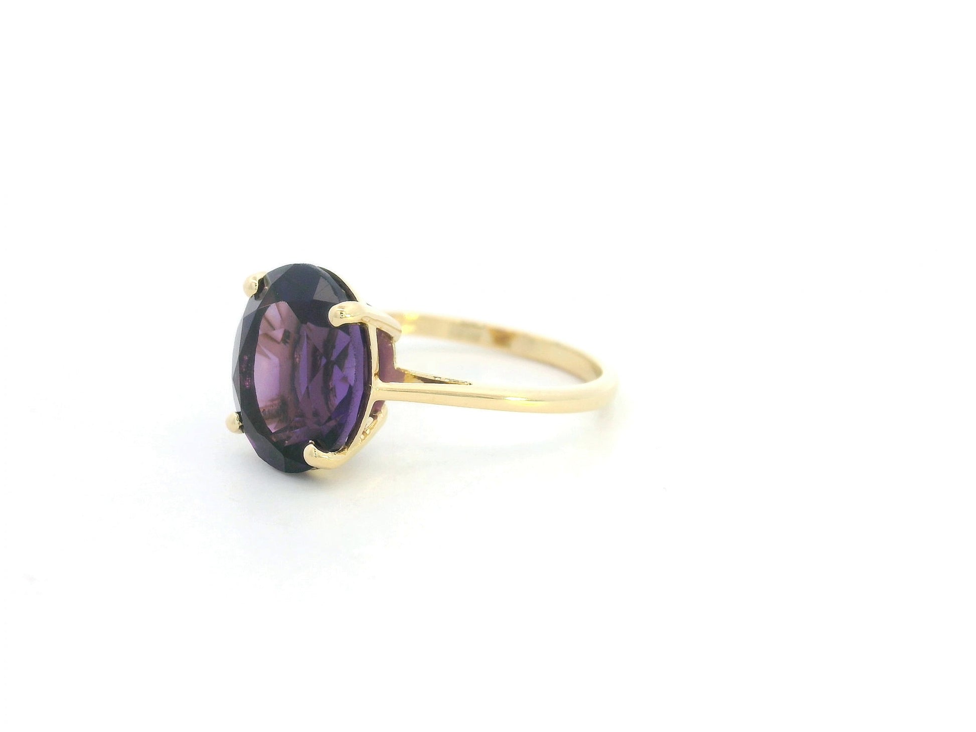Oval amethyst solitaire ring in 18K yellow gold featuring a 4.39 carat natural amethyst by Emirates Diamonds.