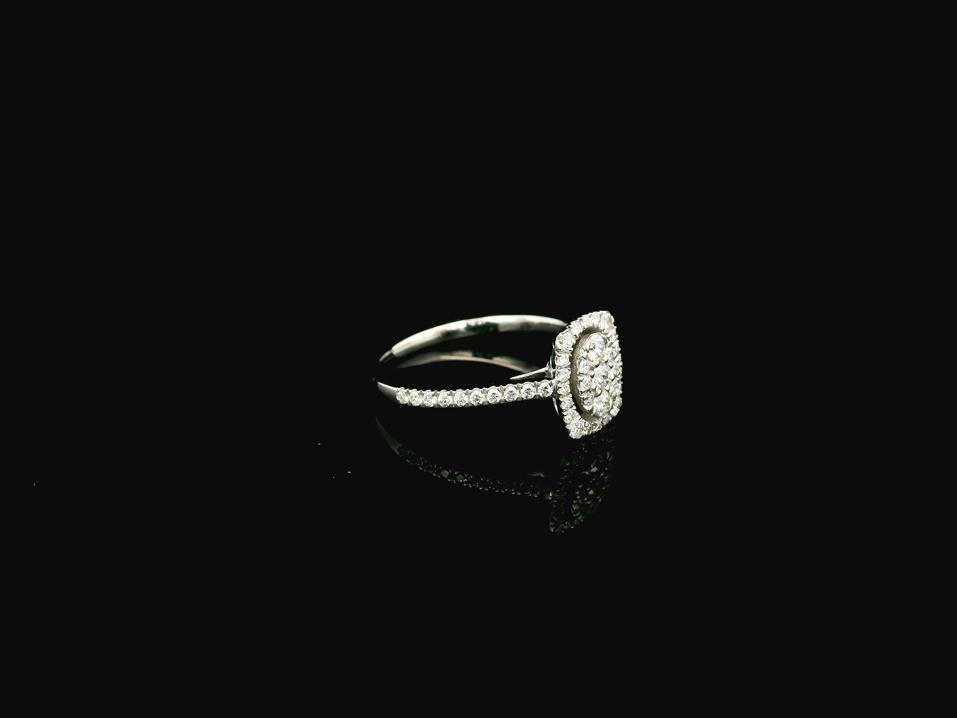 Diamond cluster halo ring in 18K white gold with oval diamond cluster and pavé band
