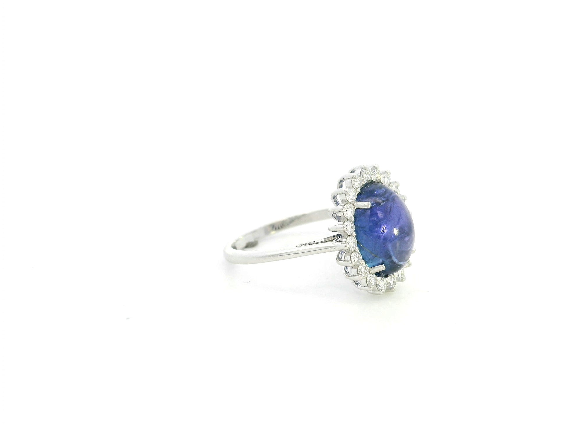 Cabochon tanzanite diamond halo ring in 18K white gold with oval blue tanzanite