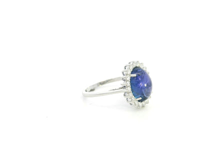 Cabochon tanzanite diamond halo ring in 18K white gold with oval blue tanzanite