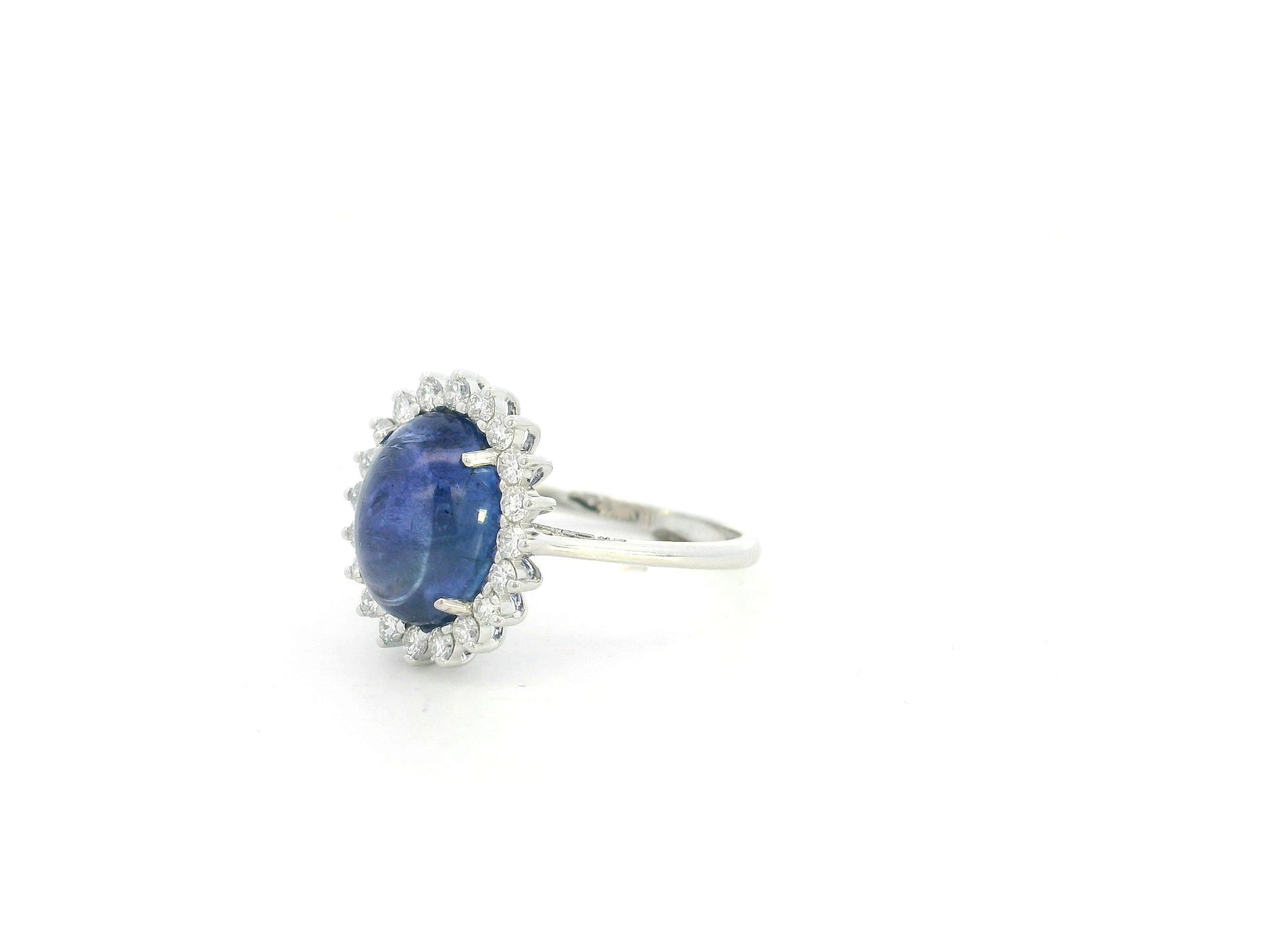 Cabochon tanzanite diamond halo ring in 18K white gold with oval blue tanzanite