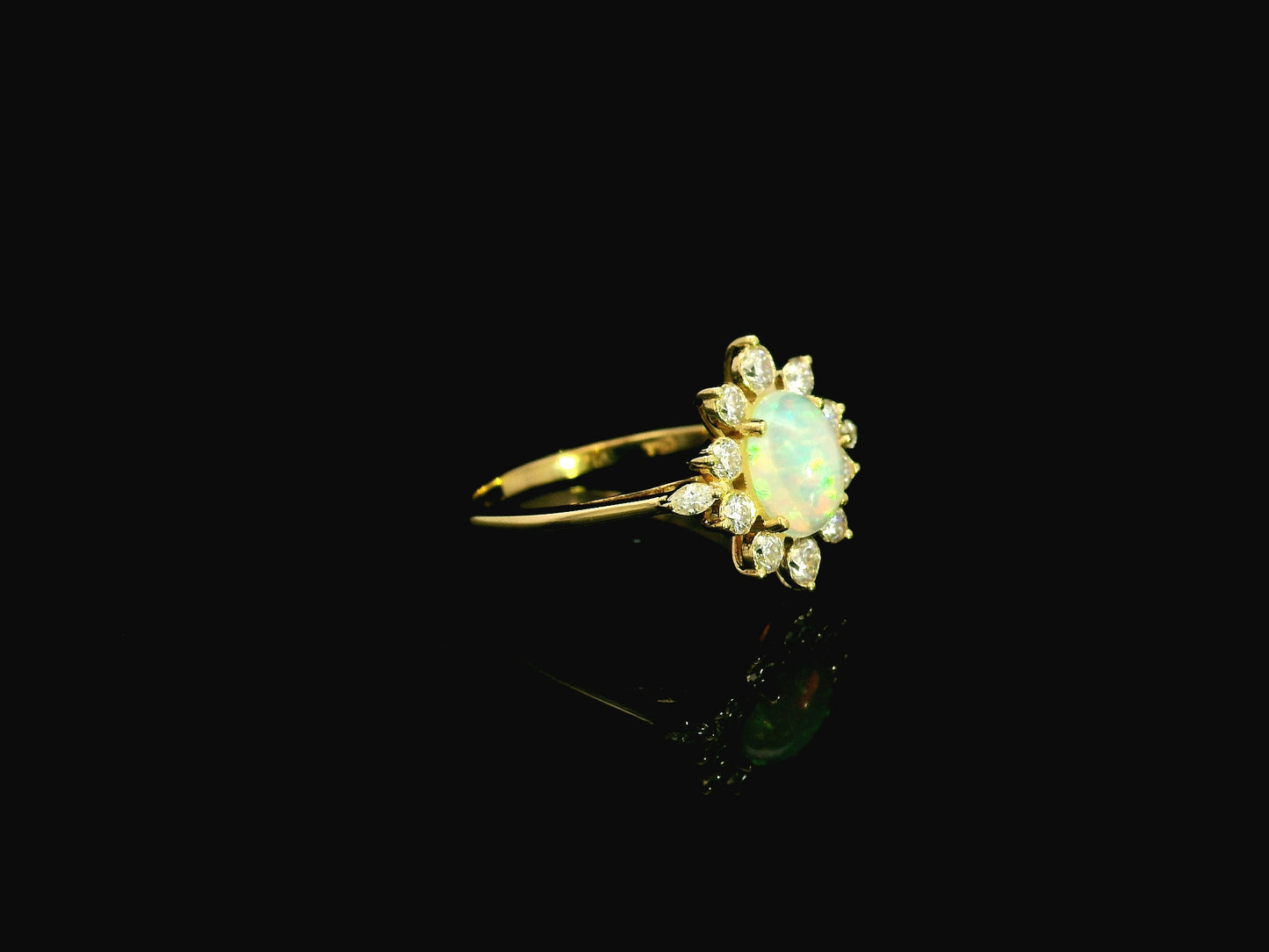 Oval opal diamond halo ring in 18K yellow gold with sunburst cluster design Emirates Diamonds