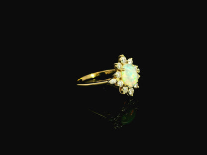 Oval opal diamond halo ring in 18K yellow gold with sunburst cluster design Emirates Diamonds