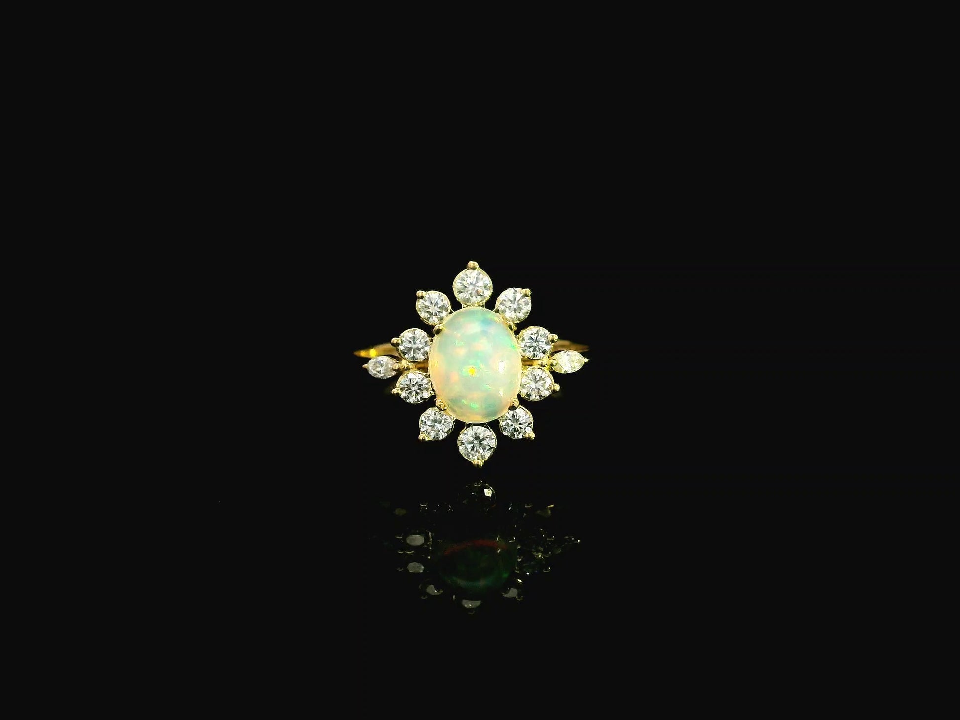 Oval opal diamond halo ring in 18K yellow gold with sunburst cluster design Emirates Diamonds