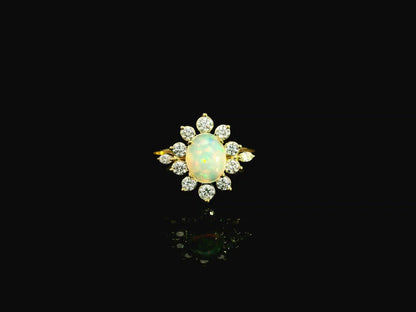 Oval opal diamond halo ring in 18K yellow gold with sunburst cluster design Emirates Diamonds