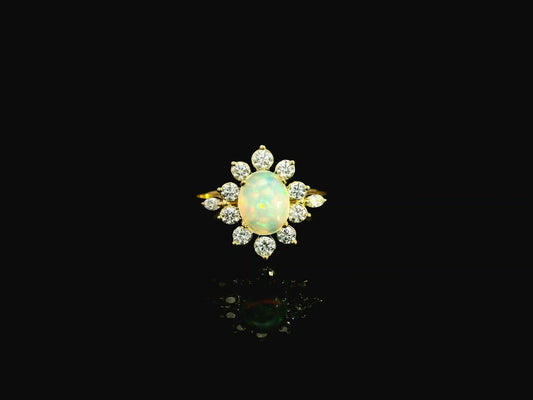Oval opal diamond halo ring in 18K yellow gold with sunburst cluster design Emirates Diamonds