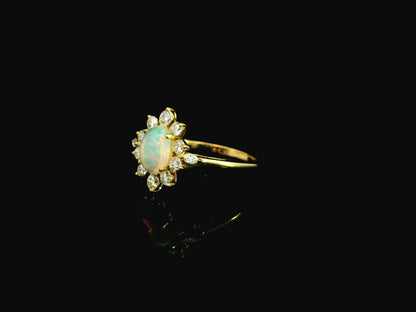 Oval opal diamond halo ring in 18K yellow gold with sunburst cluster design Emirates Diamonds