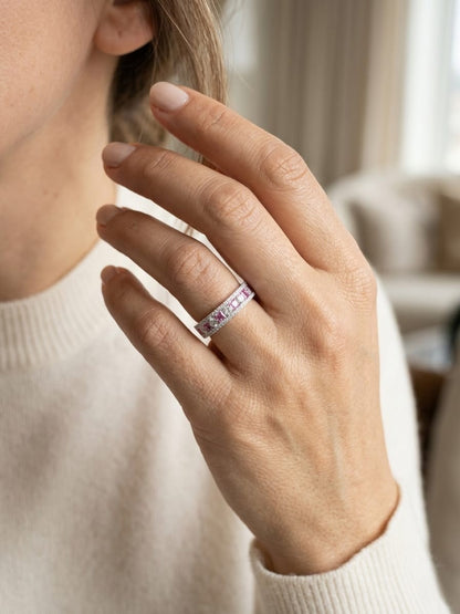 Pink sapphire diamond eternity band ring in 18K white gold with alternating princess cut sapphires