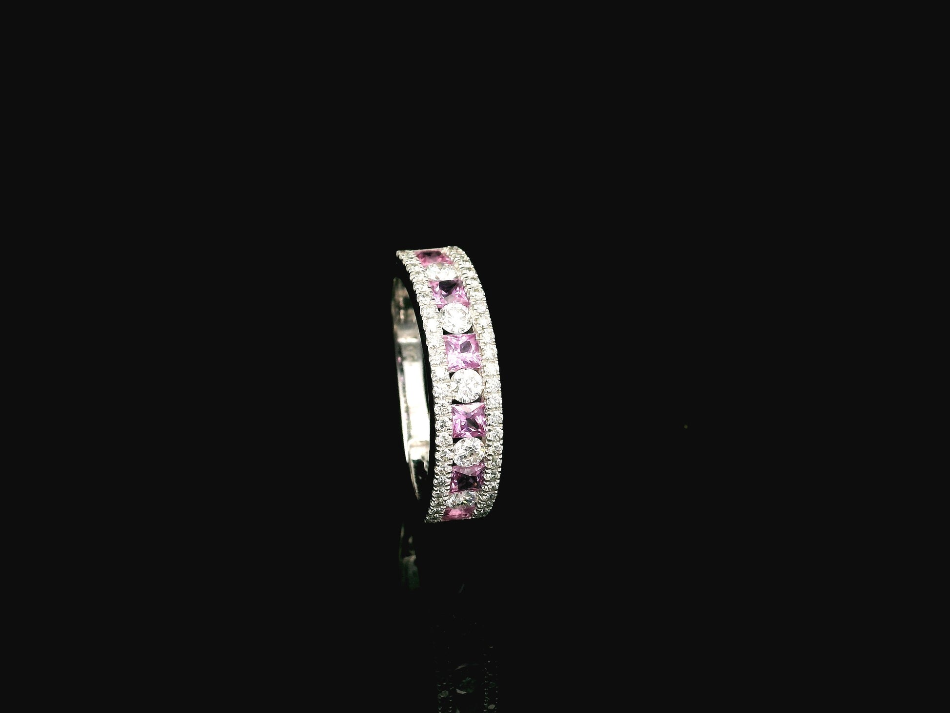 Pink sapphire diamond eternity band ring in 18K white gold with alternating princess cut sapphires